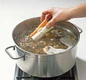 Adding vegetables to mixture in pot, step 6