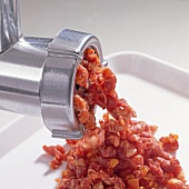 Close-up of meat being grinded in meat grinder, step 1