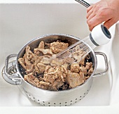Hand washing chicken stock in pot, step 4