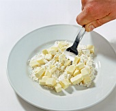 Hand mixing flour and butter on plate, step 1