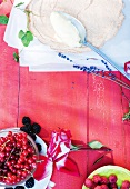 Bowl of berries and rose on wooden table