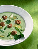 Watercress soup with meatballs on plate
