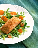 Salmon fillet with sesame crust and vegetables on plate