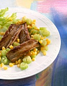 Close-up of ribs fillet with celery and corn on plate