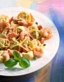 Close-up of tortellini pasta with shrimp, tomato and zucchini on plate