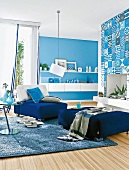 Wohnzimmer in Blau mit Sessel, Hocker und Hängeboards