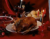 Roasted goose stuffed with prunes and apples with potato dumplings on serving dish