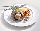 Quail with liver filling and mushroom sauce in crepe on plate