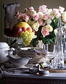 Crockery, fruits and flowers on table