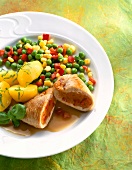 Close-up of stuffed turkey escalopes with vegetables and potatoes on plate