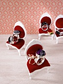 Set of silver and gold rings on dollhouse chairs
