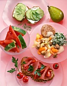 Cucumber sandwiches, pear, melon, veal fillet with vegetables and ham sandwiches on plate