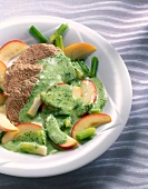 Close-up of boiled beef with spinach sauce and apples on plate