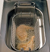 Duck leg being fried in frying basket, step 4