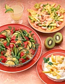 Vegetable casserole, quark dessert, green salad with shrimp with kiwi on table