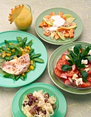 Fish fillet with green peas, tomato salad, sauerkraut salad and cereals on plates