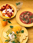 Curd cheese dish, tomato soup and fruits on plates