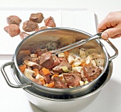 Close-up of separating meat from vegetables while preparing venison stew, step 6
