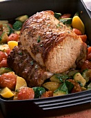 Close-up of pork loin braised with vegetables in baking dish