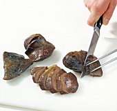 Close-up of hands cutting slices of heart on chopping board, step 6