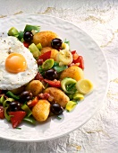 Egg on potato and vegetable stir fry on plate