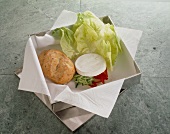 Lunchpaket: Brötchen mit Salat, Camembertkäse unf Paprika, close-up.