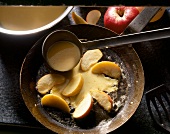 Pfannkuchen mit Apfelspalten in der Pfanne, Step, close-up.