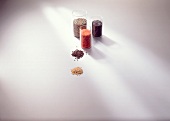 Different types of lentils in glass container on white background