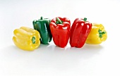 Yellow, green and red bell peppers on white background