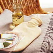 Relax-Massagen - Wolldecke, Wärm -flasche, Öl, CDs auf einem Stuhl