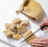 Close-up of hands cutting tripe into pieces, step 1