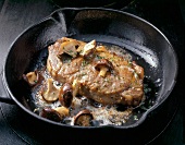 Close-up of beef sirloin steak with mushrooms in pan