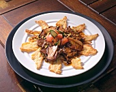 Beef fillet slices with mushrooms and zucchini flowers on plate