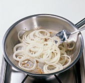Onion rings being fried in pan, step 2
