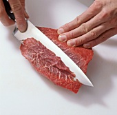 Close-up of filleting beef for preparation of hamburgers, step 1