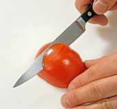 Close-up of tomato being carved for decoration, step 1