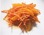 Close-up of carrot salad with orange dressing on white board