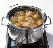 Close-up of potatoes being boiled in pot, step 1
