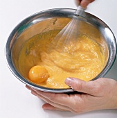 Carrot puree with egg yolk being whisked in bowl, step 1