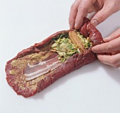 Meat with filling being rolled up for preparation of beef tartare, step 3
