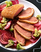 Marinated duck breast with cauliflower and red onions on plate