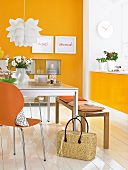 Essplatz mit orangefarbener Wand Sitzbank und Esstisch