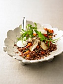 Red rice salad in serving dish with spoon
