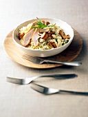 Bowl of chicken and chanterelle risotto with fork on plate