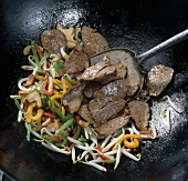 Slices of beef with vinaigrette, ablosche and various vegetables in wok, step 4