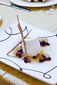 Close-up of ricotta mousse in marsala sauce with baked pears and raisins on tray