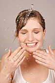 Charlotte Frau mit blonden Haaren reinigt Gesicht mit Wasser