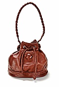 Close-up of brown leather bag with braided handle on white background