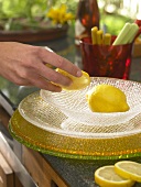 Lemon and lemon slices being kept on glass plates in summery colour