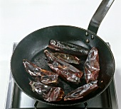 Dried chillies in frying pan on stove, step 4